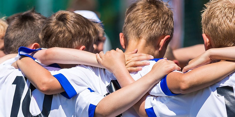 kinderen in een huddle - armen over elkaar schouders