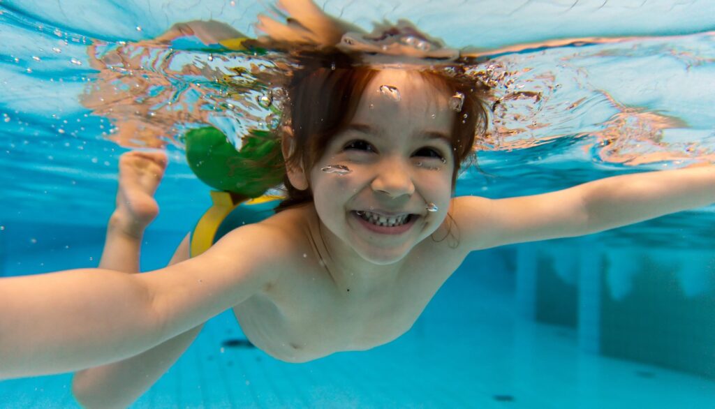 Kind in het water met glimlach op gezicht